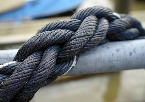 A braided black rope twists around an iron pipe