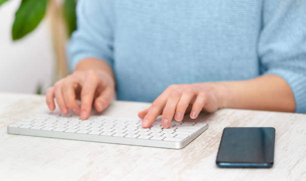 istock Female typing text on white keyboard on blue background. Freelance 1493539367