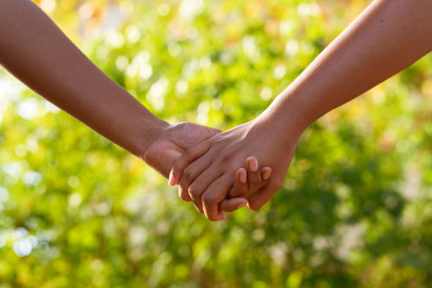 istock Two Black women hold hands outdoors, love nature romance concept 1493539425