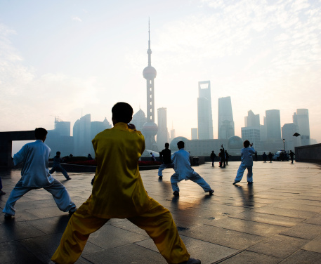 People playing Taiji on the Bund, Oriental Pearl Tower in the distance, in Shanghai, China.  One of the Top Ten Shanghai Attractions.