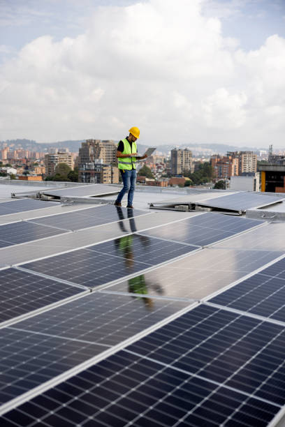 ingenieur, der die niveaus der stromversorgung von sonnenkollektoren liest - roof men business city stock-fotos und bilder