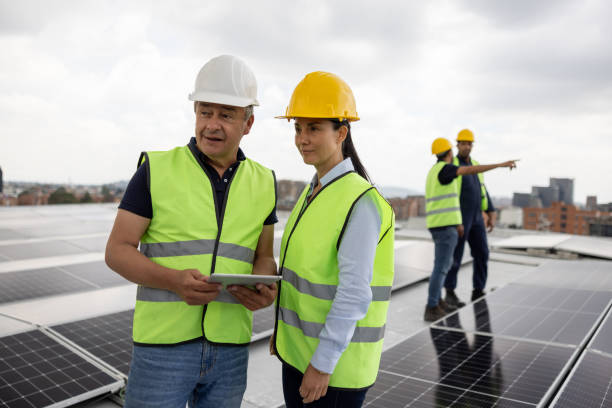 istock Team of power engineers installing solar panels on a rooftop 1493546134