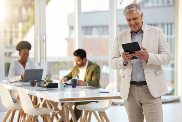 istock Business, man and tablet with connection, staff and happiness for website launch, data analysis or workplace. Mature male manager, black woman or employees in office, planning or analytics for profit 1493549098