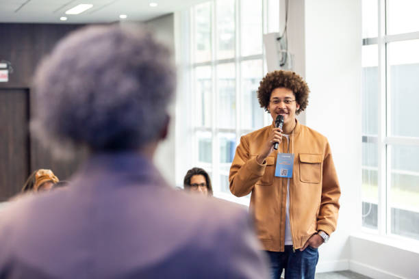 istock Black man from the audience talking into a microphone 1493549268