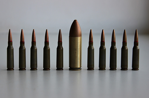 Large Caliber Bullets A Line Of Identical Regular Caliber Bullets With One Huge Large Caliber ...