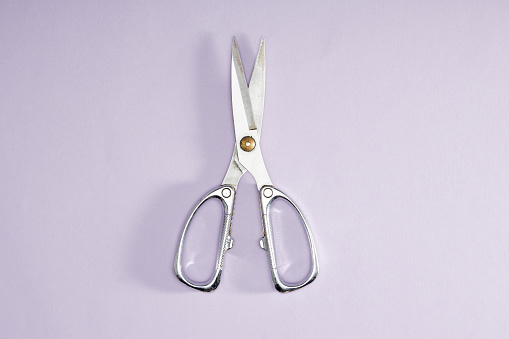 Top View Of Scissors On Purple Background