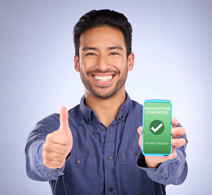 Asian man, phone and thumbs up on mockup in ecommerce, transaction or internet banking success. Portrait of happy male showing smartphone screen with thumb emoji, yes sign or like for online purchase
