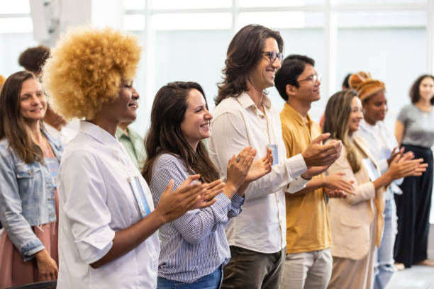 istock Black woman applauding with crowd in auditorium 1493555677