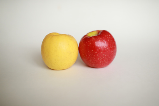 yellow red apple in front of white background
