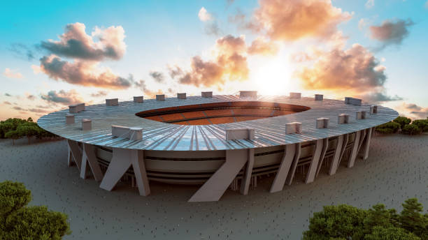 Outside view of big stadium with people walking towards the entrances. Sun is setting. Stadium could be for various sports like soccer, football or atlethics.