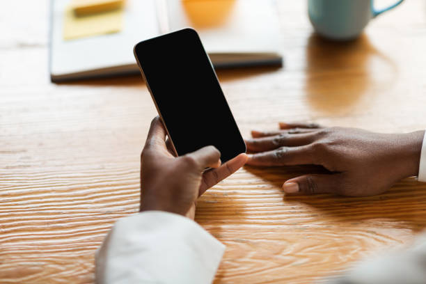 istock Cropped of black woman holding cell phone with empty screen 1493559255