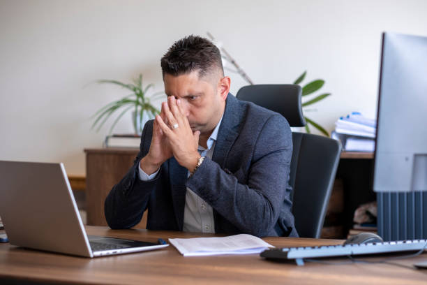 istock handsome businessman with his hand on his chin looking at his computer 1493559813