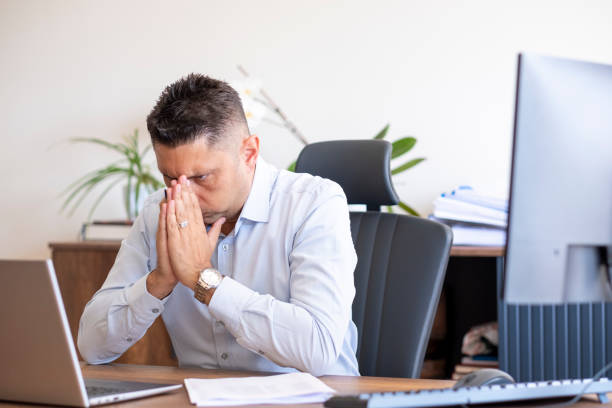 istock handsome businessman with his hand on his chin looking at his computer 1493559832