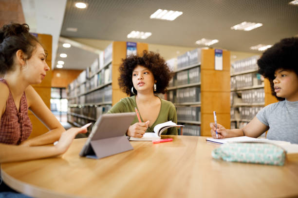 istock Group of girls studying together at the library 1493561159