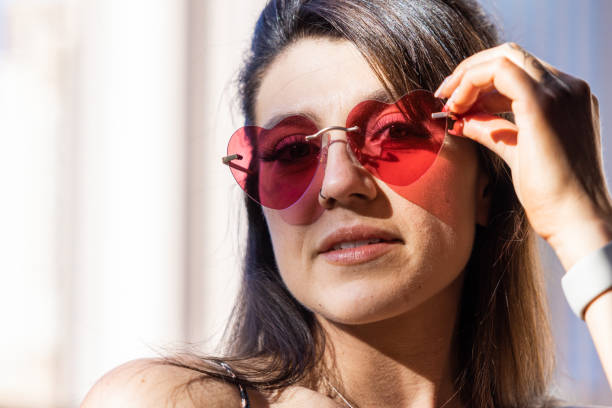 modello femminile attraente con occhiali a forma di cuore - blocking sled foto e immagini stock