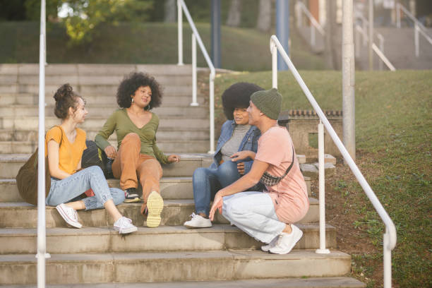 istock Friends chatting while sitting on the stairs at the campus 1493562357
