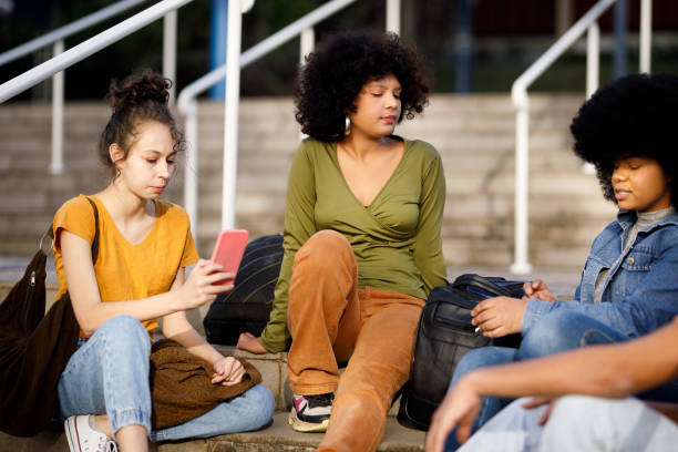 istock Friends chatting while sitting on the stairs at the campus 1493562419