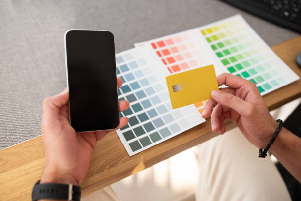 istock Male hands holding phone with blank screen and bank card 1493565704
