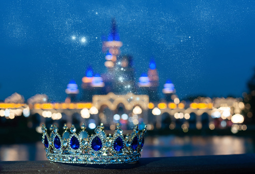 Blue crown with blue gems on castle background. Fairy tale