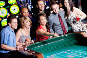 Large group of happy diverse people at the craps table
