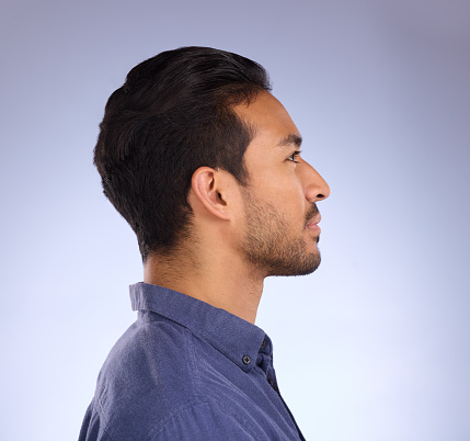 Profile, head and thinking with a man in studio on a gray background looking thoughtful or contemplative. Idea, side and face with a handsome young male contemplating a thought on a color wall