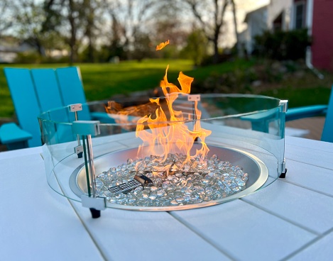 Modern fire pit table backyard deck relaxation.