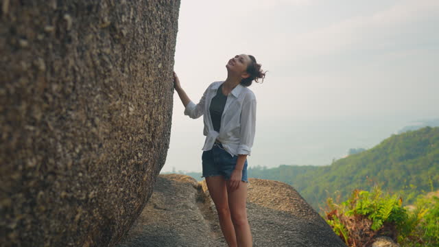 Woman near the rock stuck on the mountain overlooking Ko Samui island