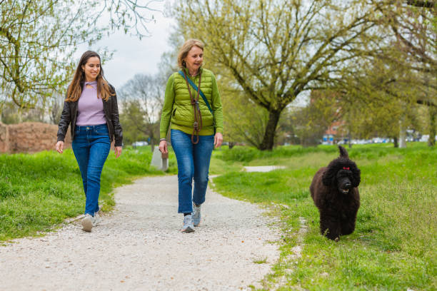istock Mother and daughter walking the dog 1493572621