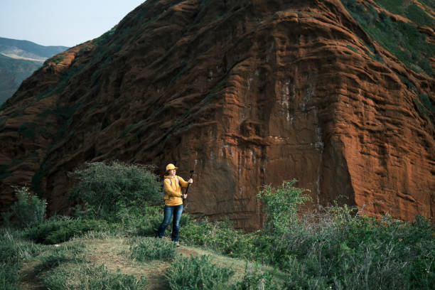 istock Cheerful female hiker is vlogging in mountains using action camera and monopod 1493572879