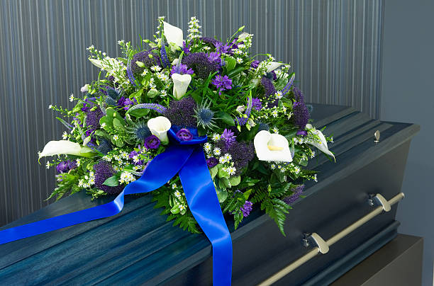 Coffin in morgue A blue coffin in a morgue with a flower arrangement coffin crematorium stock pictures, royalty-free photos & images