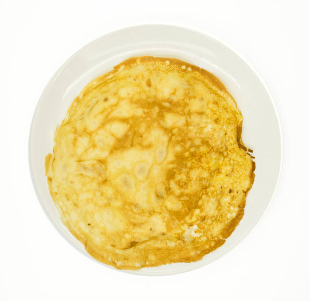istock Pancake freshly made shot from above on white plate on white background. 1493576938