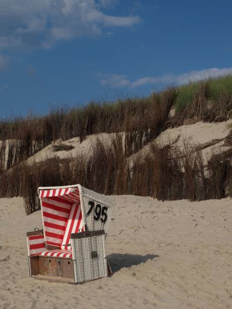 istock Red striped beach chair on the sandy shore. Langeoog, Germany. 1493580079