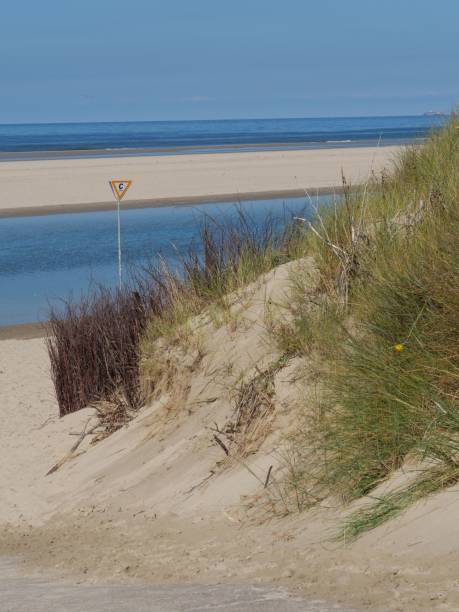 istock Tranquil beach scene with a sign on the sandy shore. Spiekeroog, Germany. 1493580170