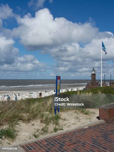 Sandy Shore With Multiple Beach Chairs And A Clock Tower In Wangerooge Germany Stock Photo - Download Image Now