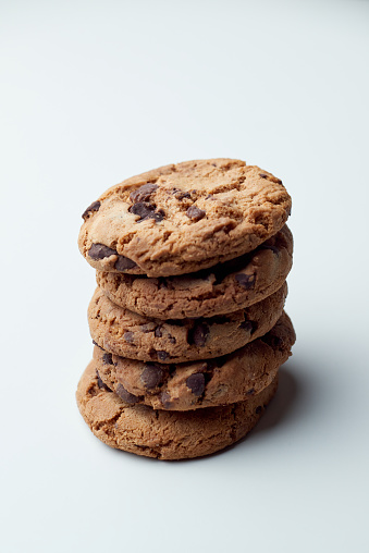 Fresh baked dark chocolate chip cookies on clear white, a sweet favorite snack
