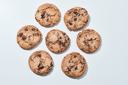 Glass of milk and chocolate chip cookies on wooden background