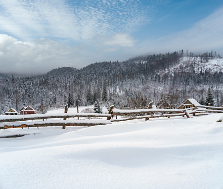 Countryside hills, groves and farmlands in winter remote alpine mountain village