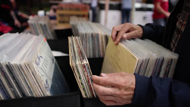 Unrecognizable senior man, browsing through box with vinyl records at the outdoor record market