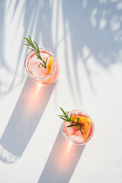 istock Top view of fresh grapefruit or red orange cocktails, with ice cubes, fresh fruit slices inside and rosemary. Vacation and summer cocktails concept. Citrus drink. 1493590198