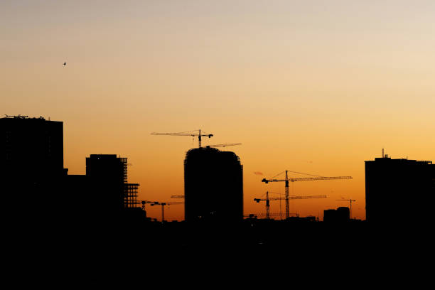 istock Silhouette of a skyscraper under construction and cranes in the evening sky. 1493590354