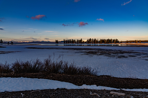 Early morning dawn view across Yellowstone Lake at Pelican Point in the Yellowstone Ecosystem in western USA and North America. Nearest cities are Gardiner, Cooke City, Bozeman, Billings, Montana, Jackson, Wyoming, Salt Lake City, Utah and Denver, Colorado.