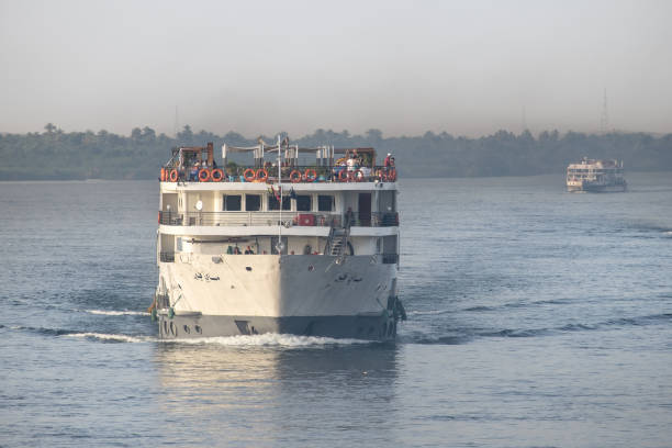 Edfu, Egypt - April 24, 2023: Cruise ships sailing down the Nile River amid clouds of smoke