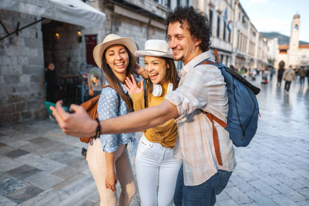 istock Three smiling tourists taking selfies in the old town square 1493595159