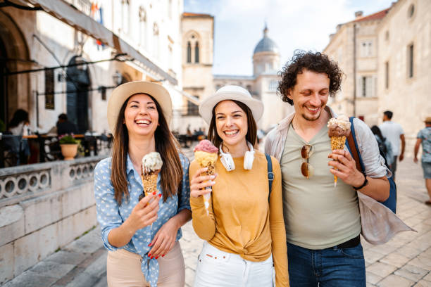 istock Three smiling tourists eating ice cream while exploring the city 1493595490