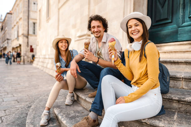 istock Three smiling tourists eating ice cream in the city 1493595621