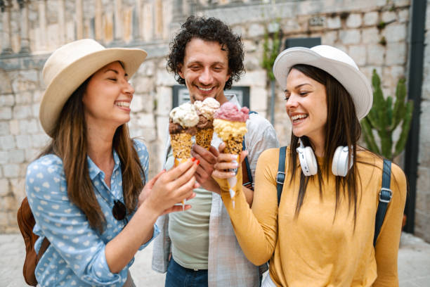 istock Three smiling tourists eating ice cream while exploring the city 1493595622