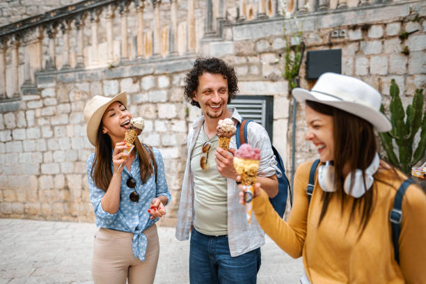 istock Three smiling tourists eating ice cream while exploring the city 1493595704
