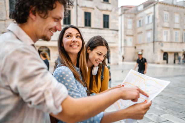 istock Three young tourists looking at the map while exploring the city 1493595755