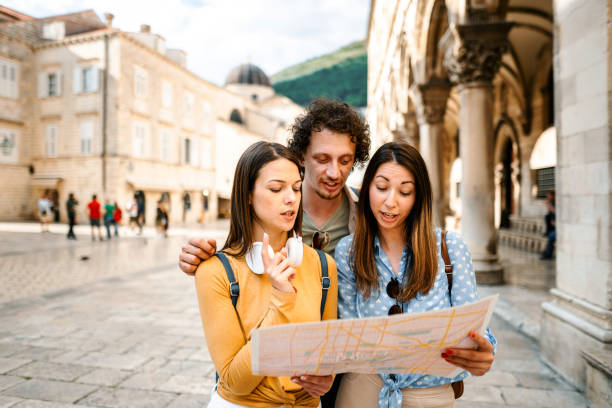 istock Three young tourists looking at the map while exploring the city 1493595756
