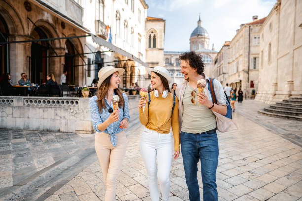 istock Three smiling tourists eating ice cream while exploring the city 1493595757